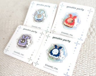 Op de afbeelding: Vier witte vierkante kaarten met afgeronde hoeken met daarop een cartoonfiguur met konijnenoren en een ander kleurenschema voor elke kaart. Elke kaart heeft de tekst "genshin party" en "ENAMEL PIN" met de website "HIDEAWAYMELON.COM".