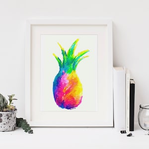 Pode incluir: Uma impressão emoldurada de uma pintura abstrata colorida de um abacaxi. O abacaxi é pintado em tons de rosa, laranja, amarelo, verde e azul. A impressão é emoldurada em uma moldura branca e é exibida em uma prateleira branca com uma pequena planta em vaso e um castiçal.