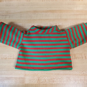 May include: Red and green striped long-sleeved shirt for a doll.