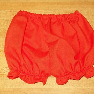 Pode incluir: Calções de bebé vermelho brilhante com cós elástico e aberturas das pernas com babados. Estes calções são feitos de um tecido macio e são projetados para conforto e estilo. Perfeitos para o guarda-roupa de um bebé.