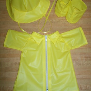 May include: A yellow raincoat with a zip fastening, a matching hat, and two boot covers.
