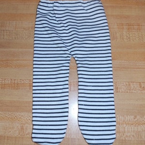 May include: White and black striped pants with a black elastic waistband.