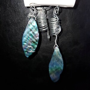 May include: Two silver wire hair wraps with iridescent blue and green abalone shell charms.