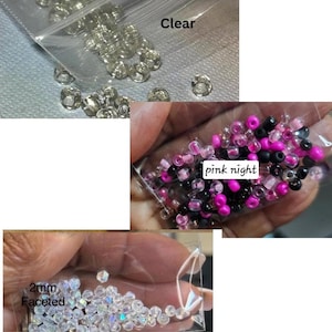 May include: Three small plastic bags filled with beads. One bag contains clear, round beads, another contains pink, black, and fuchsia beads, and the third contains 2mm faceted beads. The text "Clear", "pink night", and "2mm Faceted" are visible.