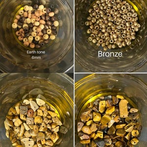 May include: Four glass jars filled with beads and stones. The top left jar contains earth tone beads, 6mm in size. The top right jar is filled with bronze beads. The bottom left jar contains jasper stones, and the bottom right jar has tiger's eye stones.