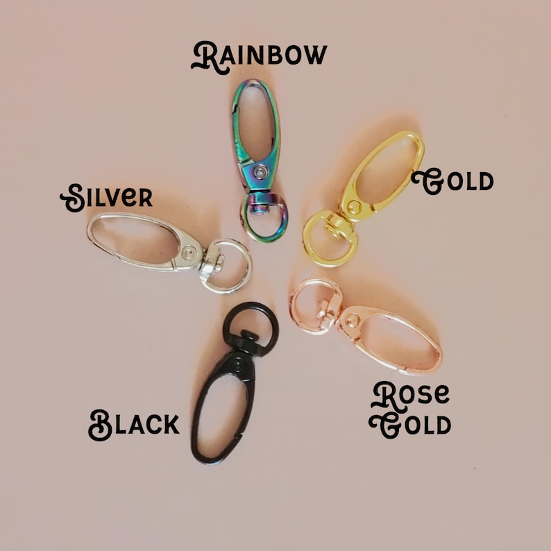 May include: Five different colored metal lobster clasps, including rainbow, silver, gold, rose gold, and black.