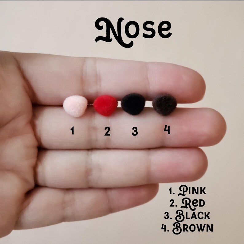 May include: Four pom-poms in different colours: pink, red, black, and brown. The pom-poms are numbered 1 through 4. The text "Nose" is at the top of the image. The text "1. PINK, 2. RED, 3. BLACK, 4. BROWN" is at the bottom of the image.