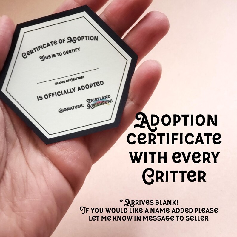 May include: A hexagonal certificate of adoption with black borders and white text. The text reads "Certificate of Adoption" and "This is to certify". The certificate is blank and has a space for the name of the critter and a signature line. The text "Signature: Fairyland Amigurumi" is printed below the signature line. The certificate is held in a hand. The text "Adoption Certificate with Every Critter" is printed below the certificate. The text "* Arrives Blank! If you would like a name added please let me know in message to seller" is printed below the text "Adoption Certificate with Every Critter".