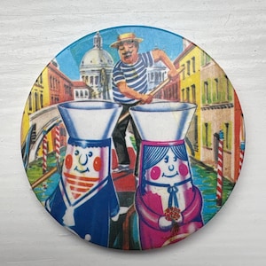 May include: A round, colorful illustration of Venice, Italy. A gondolier in a striped shirt rows a gondola with two cartoon figures. The background features buildings, a bridge, and a blue sky.
