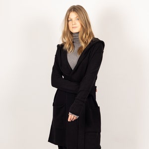 Stay cozy and chic in the EDITH black hooded cashmere cardigan or jacket by Krista Elsta, featuring a fashionable and elongated silhouette.