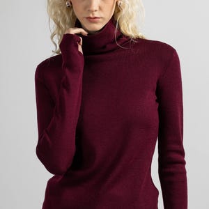 Close-up of the clean, simple lines of a red merino wool turtleneck sweater.