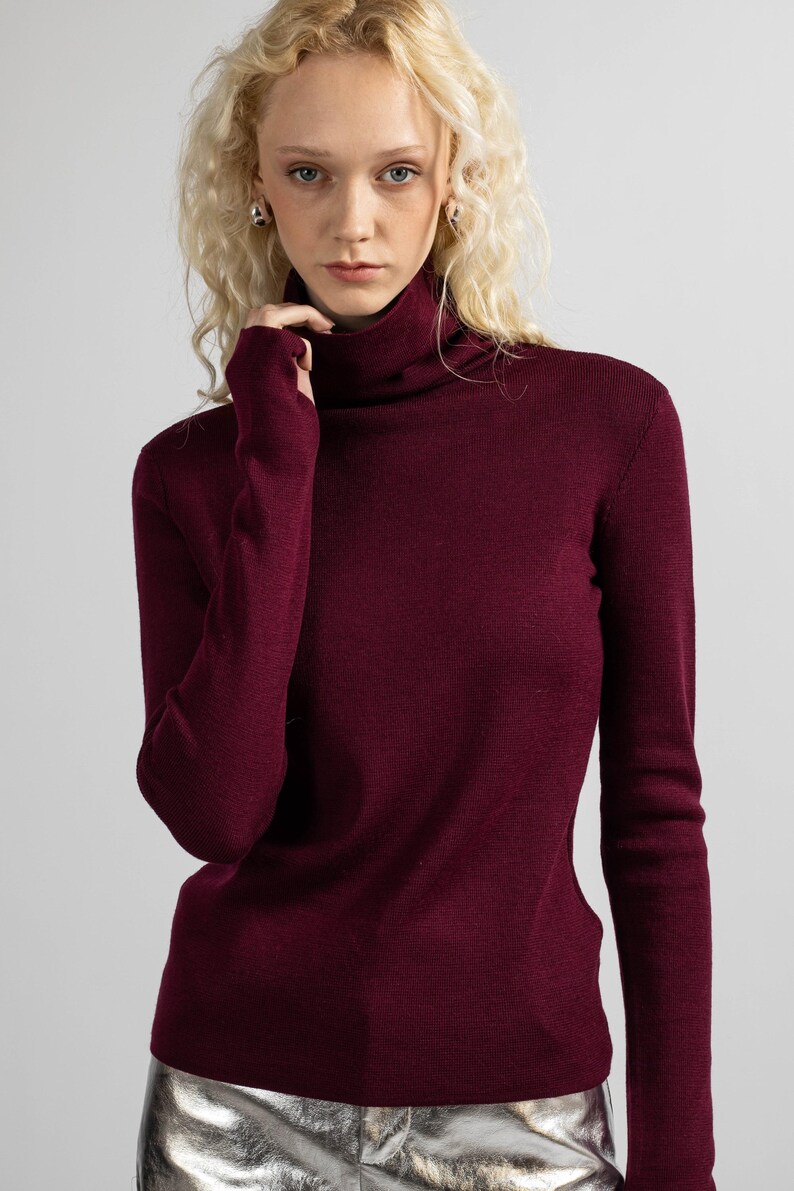 Close-up of the clean, simple lines of a red merino wool turtleneck sweater.