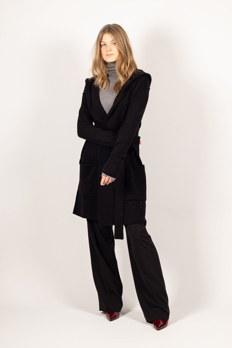 Stay cozy and chic in the EDITH black hooded cashmere cardigan or jacket by Krista Elsta, featuring a fashionable and elongated silhouette.