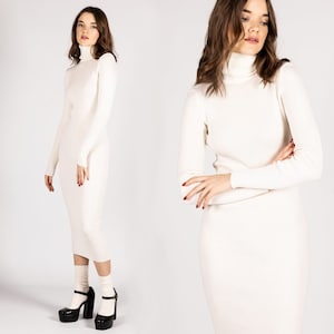 K&ouml;nnte beinhalten: Ein wei&szlig;es Rollkragenpulloverkleid mit langen &Auml;rmeln. Das Kleid ist figurbetont und hat eine gerippte Struktur.