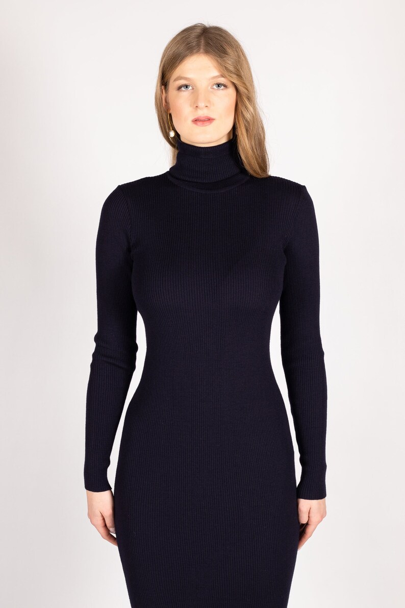 Op de afbeelding: Een lange, donkerblauwe trui met een geribbelde textuur.