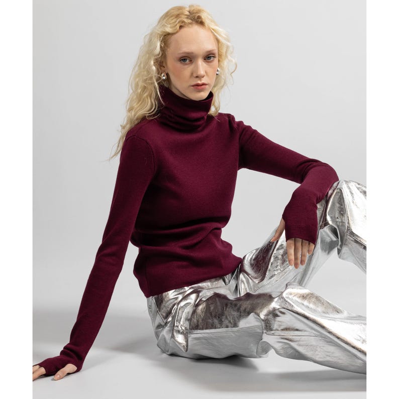 Front view of a burgundy merino wool turtleneck sweater for women, with long sleeves.