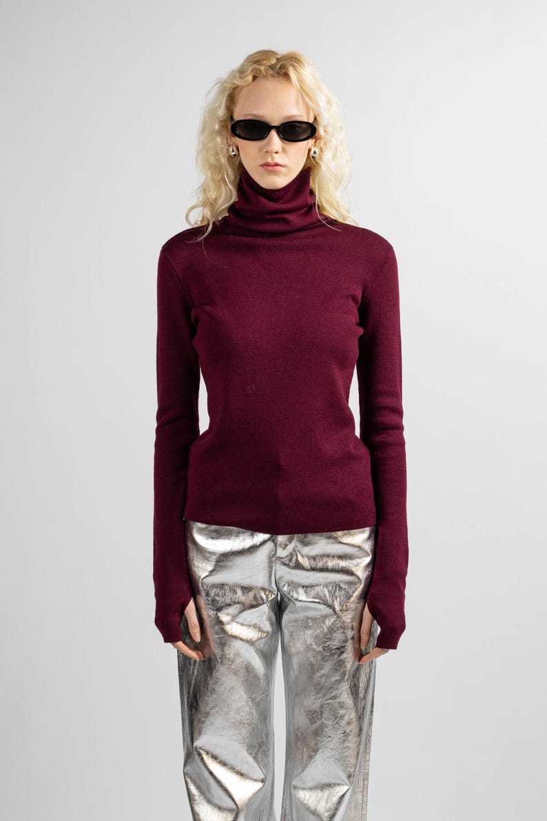 Burgundy red wool sweater featuring a high neck and soft merino wool texture.