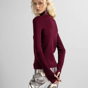 Back view of the deep burgundy merino wool sweater showing its clean, streamlined design.