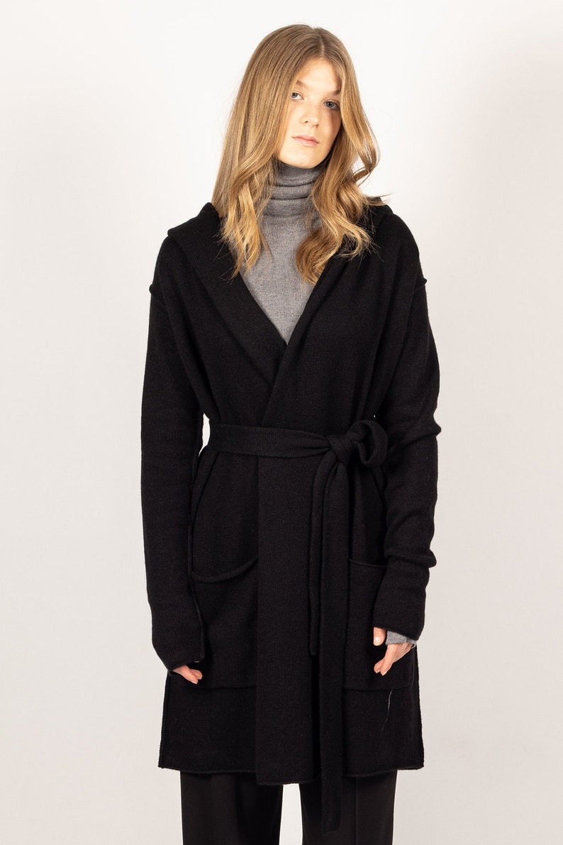 Elevate your wardrobe with the EDITH black hooded cashmere cardigan or jacket from Krista Elsta, offering a luxurious and elongated design.