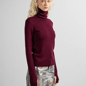 Side view of a women’s red merino wool sweater with a sleek, flattering fit.