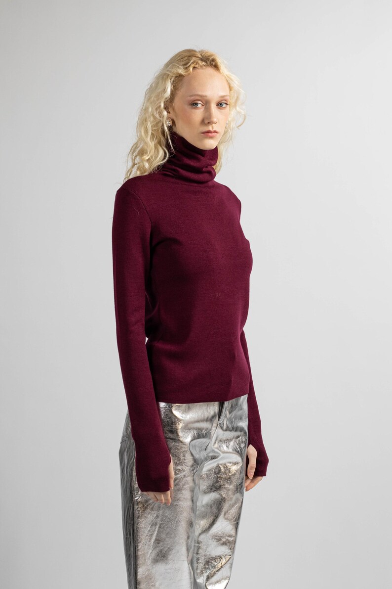 Side view of a women’s red merino wool sweater with a sleek, flattering fit.