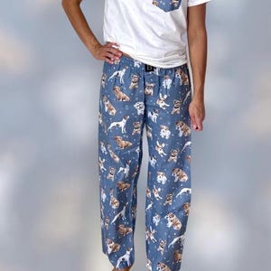 May include: Blue pajama pants with a pattern of various dog breeds. The pants have an elastic waistband and a drawstring.
