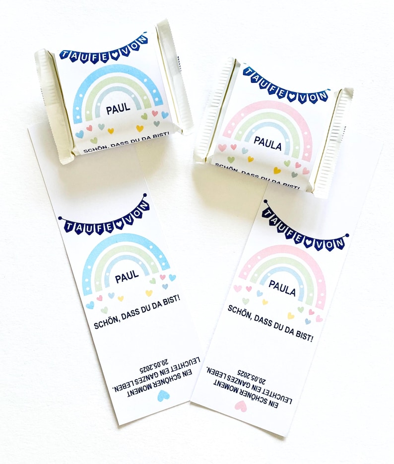May include: White candy wrappers and bookmarks with rainbow designs. The wrappers and bookmarks feature the names "PAUL" and "PAULA", with text in German. The design includes a rainbow, hearts, and the words "TAUFE VON".