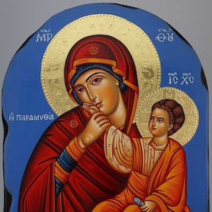 Può includere: Un'icona dipinta a mano che raffigura la Vergine Maria che tiene in braccio il bambino Gesù. L'icona è dipinta in uno stile bizantino tradizionale con accenti in foglia d'oro. Lo sfondo è di un blu vibrante. L'iscrizione sull'icona recita "Η ΠΑΡΑΜΥΘΙΑ", che si traduce in "La Consolazione".