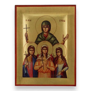 Può includere: Icona religiosa raffigurante una figura centrale con un'aureola, circondata da tre figure più piccole, anch'esse con aureole. Le figure tengono croci e indossano abiti religiosi tradizionali. Lo sfondo è dorato con un bordo rosso.