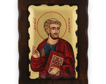 May include: A framed icon of Saint Luke, a Christian apostle and evangelist. The icon is painted in a traditional style with gold leaf accents. The inscription "O' Aγιoς Λουκας" is written in Greek on the icon.