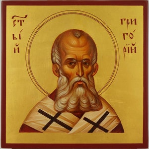 Könnte beinhalten: Eine handgemalte Ikone des Heiligen Nikolaus, einer religiösen Figur im Christentum. Die Ikone ist auf einem Holzpaneel gemalt und hat einen goldenen Hintergrund mit einem Heiligenschein um den Kopf des Heiligen. Der Heilige ist mit einem weißen Bart und einer rot-weißen Robe dargestellt. Die Ikone ist mit dem Text "Γρηγόριος" in Griechisch beschriftet.