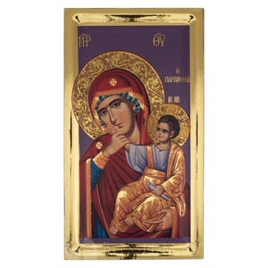 Può includere: Icona religiosa con cornice dorata raffigurante la Vergine Maria e il bambino. L'immagine mostra Maria con una veste e un copricapo rossi, che tiene in braccio il bambino. Lo sfondo è viola con dettagli dorati.