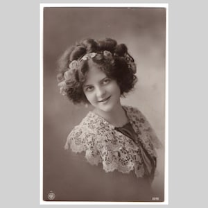 Postal de moda vintage: Retrato de una joven con cuello de encaje glamuroso. Tarjeta de felicitación antigua de RPC, ca. 1910.