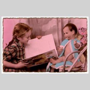 Postal antigua con foto real: una niña pequeña lee un cuento a su muñeca títere. Tarjeta de felicitación francesa antigua sin usar, circa 1935.