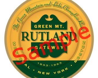 May include: A round, gold-coloured ornament with a green and yellow design. It features the text "The Green Mountain and Lake Champlain Route", "GREEN MT.", "RUTLAND GATEWAY", "MONTREAL", "BOSTON", "1843-1963", and "NEW YORK".