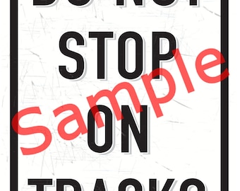 May include: A white metal sign with black text that reads "DO NOT STOP ON TRACKS". The sign has a distressed, vintage look and is a sample.
