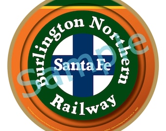 May include: A round ornament with the Burlington Northern Santa Fe Railway logo. The design features a green circle with white text, an orange border, and a blue cross. The text "Burlington Northern Santa Fe Railway" is clearly visible.