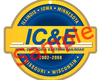 May include: A round, gold-coloured ornament with a blue centre circle. The text "IC&E" is in large, white letters on the yellow background. The text "IOWA, CHICAGO & EASTERN RAILROAD" is in smaller white letters below the large letters. The years "2002-2008" are in white letters below the railroad name. The text "ILLINOIS • IOWA • MINNESOTA • MISSOURI • WISCONSIN" is in white letters around the outer edge of the ornament.