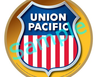 May include: A circular, gold-coloured ornament displaying the Union Pacific logo. The logo is a blue shield with the words "UNION PACIFIC" in white, above red and white stripes. The word "Sample" is overlaid in a transparent blue-green colour.