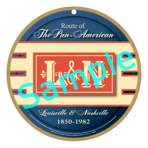 May include: A round, blue and gold, decorative ornament with the text "Route of The Pan-American" and "L&N Louisville & Nashville 1850-1982".