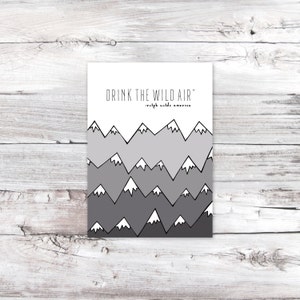 May include: A white printable art print with a black and gray mountain range design and the quote "Drink the wild air" - Ralph Waldo Emerson.