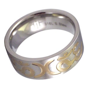 May include: A stainless steel ring with a brushed finish and a gold-colored flame design. The ring has a wide band and a polished interior. The text "316L S Steel" is visible on the inside of the ring.