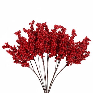 May include: A decorative floral arrangement consisting of multiple thin brown stems, each densely covered with small, glossy, vibrant red berries. The stems fan out from a central point, creating a wide, rounded, and textured botanical display.