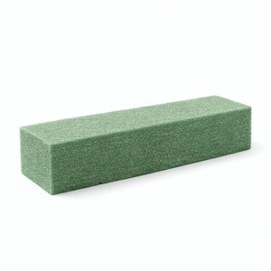May include: A rectangular, green floral foam brick. The foam has a textured, porous surface and is designed for arranging flowers. The brick is a solid, uniform color and shape, ideal for creating floral arrangements.