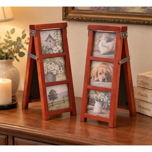 May include: Two A-frame wooden photo frames with a reddish-brown finish and silver metal hinges. Each frame holds three vertical photos stacked in a column. The left frame displays a birdhouse, daisies, and a tree. The right frame shows a heart with the word Family, a dog, and flowers in a pitcher.