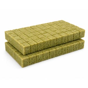 May include: Two rectangular blocks of olive green rockwool growing medium, each composed of a grid of smaller, individual square cubes. The fibrous, porous texture of the material is visible across the surface of the stacked growing cubes.