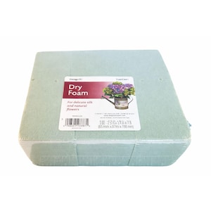 May include: A light green rectangular block of dry floral foam, wrapped in clear plastic. A white label displays the words "Dry Foam" and "For delicate silk and natural flowers". The dimensions are 2.5 in x 7.8 in.