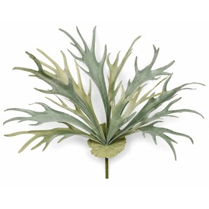 May include: An artificial staghorn fern frond featuring multiple elongated, branching leaves in shades of sage green and muted olive. The plant structure radiates from a central, circular, textured base attached to a single, short, straight stem.
