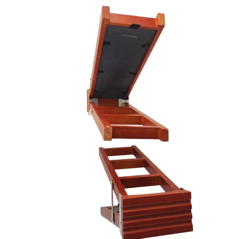 May include: A reddish-brown wooden adjustable display stand featuring a rectangular frame with a black backing panel. The stand includes a hinged support mechanism that allows for multiple angled positions, with a ribbed front edge for stability.