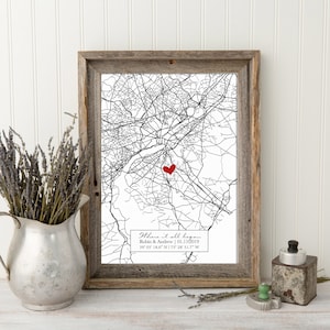 May include: A black and white map print with a red heart marking a location. The print is framed in a rustic wood frame and includes the text "Where it all began" with the names Robin & Andrew and the date 01.11.2019. The coordinates 39 05 18.6 N 75 18 31.7 W are also included.